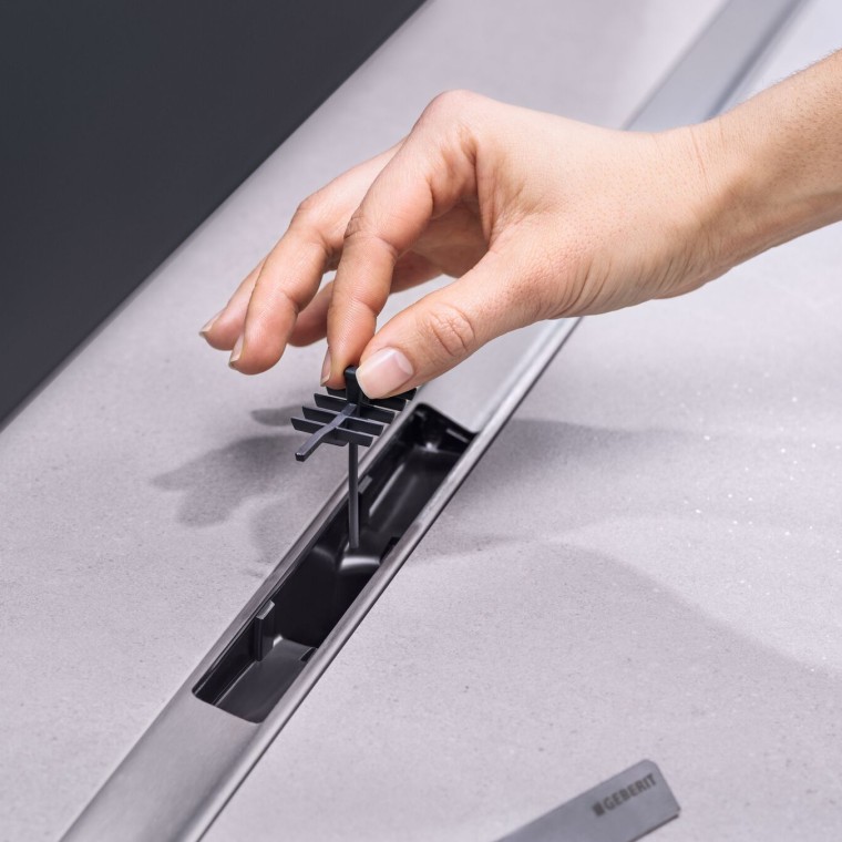 Äravoolu kammsüdamikku sisestav käsi Äravoolu kammsüdamikku sisestav käsi