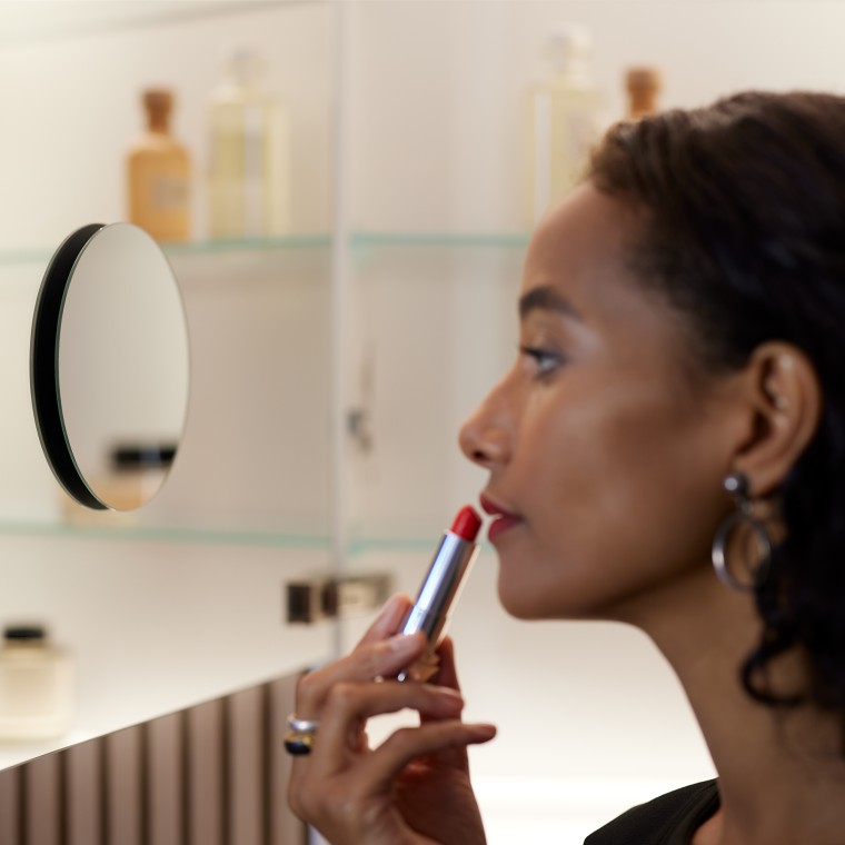 Naine meigib end peegli ees Naine meigib end peegli ees